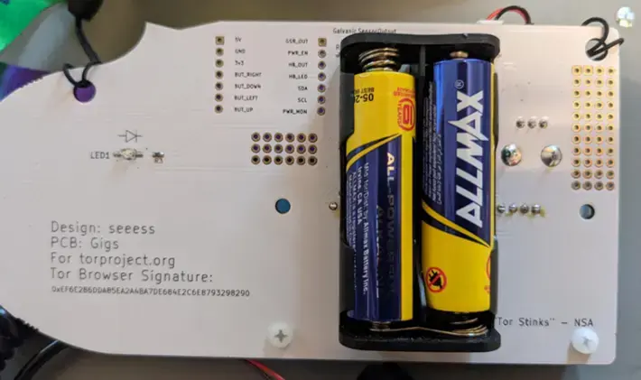 Back of the DEF CON TOR 29 badge showing two AA batteries and circuit labels