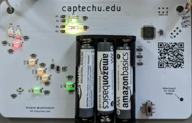 Back of the Aerospace Village badge with three AAA batteries and a QR code